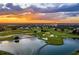 Picturesque aerial view of a golf course with a lake, bridges, and a luxurious hotel in the background at 1449 Fairview Cir, Reunion, FL 34747