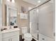 Bright bathroom featuring a glass-enclosed shower and ample vanity space at 1449 Fairview Cir, Reunion, FL 34747