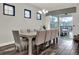 Bright dining area featuring a long wooden table, stylish chairs, and sliding glass doors to the patio at 1449 Fairview Cir, Reunion, FL 34747