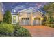 Inviting two-story home with a brick driveway, lush landscaping, and a two-car garage at 1449 Fairview Cir, Reunion, FL 34747