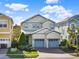 Charming two-story home with a manicured lawn and two-car garage with blue doors at 1449 Fairview Cir, Reunion, FL 34747