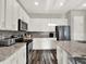 Modern kitchen featuring white cabinetry, stainless steel appliances, and granite countertops, ideal for cooking at 1449 Fairview Cir, Reunion, FL 34747
