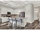 Bright kitchen with white cabinets, stainless steel appliances, a granite countertop island and modern stools at 1449 Fairview Cir, Reunion, FL 34747