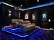 Home theater with tiered seating, projector, movie poster decor and ambient lighting at 1449 Fairview Cir, Reunion, FL 34747