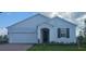 Charming single-story home featuring a two-car garage, well-manicured lawn, and elegant architectural details at 14599 Crestavista Dr, Clermont, FL 34714