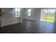 Bright, open-concept living space with dark hardwood floors, lots of natural light, and sliding glass door access to yard at 14599 Crestavista Dr, Clermont, FL 34714