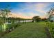 Expansive backyard with lush green grass, mature landscaping, and a tranquil lake view, perfect for outdoor enjoyment at 14749 Walcott Ave, Orlando, FL 32827