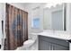 Cozy bathroom showcasing a vanity with a gray cabinet, a toilet and a colorful shower curtain at 14749 Walcott Ave, Orlando, FL 32827