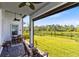 Relaxing covered patio with a ceiling fan, outdoor seating, and a serene view of the backyard and lake at 14749 Walcott Ave, Orlando, FL 32827