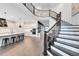 Open concept living space with gourmet kitchen, breakfast bar, and grand staircase showcasing modern design at 14749 Walcott Ave, Orlando, FL 32827
