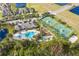 Stunning aerial view of the community clubhouse, pool, and tennis courts, surrounded by lush landscaping at 14751 Clarkson Dr, Orlando, FL 32828