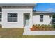 Close-up of a modern home's entry with a light-green door and decorative landscaping at 1620 Haddock St, St Cloud, FL 34771