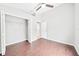 Bright bedroom with wood-look floors, ceiling fan, and closet storage at 1631 Oak Hill Trl, Kissimmee, FL 34747