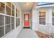 Inviting front porch with a bright red door, decorative brick accents, and lots of natural light at 1631 Oak Hill Trl, Kissimmee, FL 34747