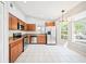 Modern kitchen features stainless steel appliances, wood cabinets, granite countertops, and bright natural light at 1631 Oak Hill Trl, Kissimmee, FL 34747