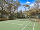 Well-maintained community tennis court with green surface, surrounded by mature trees and fencing at 1631 Oak Hill Trl, Kissimmee, FL 34747