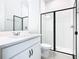 Modern bathroom featuring glass shower and white vanity with black hardware at 19065 Blueleaf St, Orlando, FL 32827