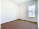 Bright bedroom featuring neutral carpet, white walls, and a window allowing for ample natural light at 19065 Blueleaf St, Orlando, FL 32827