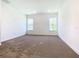 Bright bedroom featuring neutral carpet, white walls, and two windows allowing for ample natural light at 19065 Blueleaf St, Orlando, FL 32827