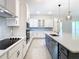 Bright, modern kitchen featuring white cabinetry, a gray island, and stylish pendant lighting at 19065 Blueleaf St, Orlando, FL 32827