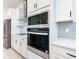 Close-up of kitchen appliances, featuring a stainless steel oven, microwave, and elegant backsplash at 19065 Blueleaf St, Orlando, FL 32827