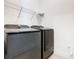 Modern laundry room featuring gray washer and dryer units with a wire rack shelving at 19065 Blueleaf St, Orlando, FL 32827