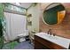 Stylish bathroom features a modern vanity, round mirror, and a shower with decorative fixtures at 2114 Bluff Oak St, Apopka, FL 32712