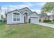Inviting single-Gathering home with manicured lawn and a two-car garage and red door on a clear day at 2122 Korat Ln, Maitland, FL 32751