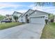 Suburban single-Gathering home showcasing a two-car garage, well-kept lawn and driveway with parking at 2122 Korat Ln, Maitland, FL 32751