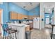 Inviting kitchen with bright blue walls, tile floors, wooden cabinets, and a breakfast bar at 2122 Korat Ln, Maitland, FL 32751