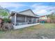 Backyard view showcasing the screened-in back porch and spacious lawn at 2122 Korat Ln, Maitland, FL 32751