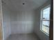 A bedroom with drywall installed, a window providing natural light, and unfinished floors, awaiting personalization at 22117 Amberbush Court, Mount Dora, FL 32757