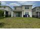 Backyard view featuring a spacious lawn and a view of neighboring homes, perfect for outdoor activities at 2620 Blowing Breeze Ave, Kissimmee, FL 34744
