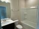 Bathroom featuring a shower-tub combo, a single sink vanity with dark cabinets, and tile floors at 2620 Blowing Breeze Ave, Kissimmee, FL 34744