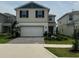 Two-story home with a two-car garage and a well-maintained front yard, highlighting curb appeal at 2620 Blowing Breeze Ave, Kissimmee, FL 34744