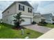 Two-story home features a two-car garage and nicely landscaped lawn at 2620 Blowing Breeze Ave, Kissimmee, FL 34744