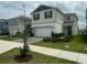 Two-story home features a two-car garage, manicured lawn, and a welcoming facade at 2620 Blowing Breeze Ave, Kissimmee, FL 34744
