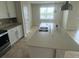 Bright kitchen features stainless steel appliances, granite countertops, tile backsplash, and double basin sink at 2620 Blowing Breeze Ave, Kissimmee, FL 34744