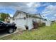 Side view of a home featuring an attached two-car garage and manicured landscaping at 2673 Dixie Ln, Kissimmee, FL 34744
