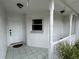 Close-up of the covered front porch featuring tiled flooring and decorative columns and plants at 2673 Dixie Ln, Kissimmee, FL 34744