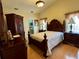 A well-decorated bedroom with an ornate bed, a high ceiling and hardwood floors at 2673 Dixie Ln, Kissimmee, FL 34744