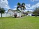 View of the home's exterior showcasing the meticulously landscaped yard with a vibrant palm tree at 2673 Dixie Ln, Kissimmee, FL 34744