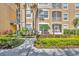 Attractive condo exterior featuring tan stucco, verdant landscaping, and a walkway at 2781 Almaton Loop # 105, Kissimmee, FL 34747