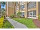 Condo exterior displaying green grass, verdant bushes, and a walkway at 2781 Almaton Loop # 105, Kissimmee, FL 34747