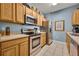 The kitchen features stainless steel appliances, light wooden cabinets, and a tiled floor at 2781 Almaton Loop # 105, Kissimmee, FL 34747