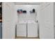 A closet containing a laundry washer and dryer with shelving above at 2781 Almaton Loop # 105, Kissimmee, FL 34747