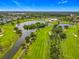 Scenic aerial view of the golf course, lake, and lush landscaping in the community at 2885 Autumn Green Dr, Orlando, FL 32822