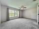 Spacious bedroom with a ceiling fan, plush carpet, and a large window for ample natural light at 2885 Autumn Green Dr, Orlando, FL 32822
