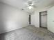 Light-filled bedroom featuring soft carpet, a ceiling fan, closet, and two entryways at 2885 Autumn Green Dr, Orlando, FL 32822