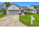 Charming home features a well-manicured lawn, mature landscaping, and a two-car garage at 2885 Autumn Green Dr, Orlando, FL 32822